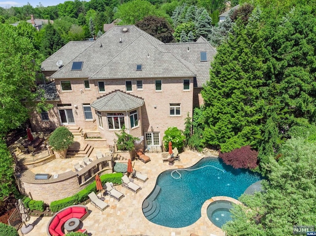 view of pool featuring a patio area and an in ground hot tub