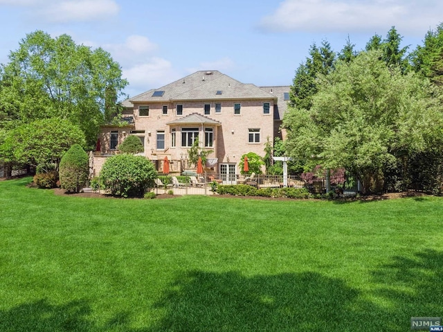 rear view of property with a yard