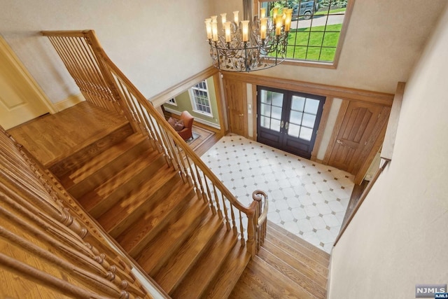 entrance foyer featuring a chandelier, french doors, and a healthy amount of sunlight