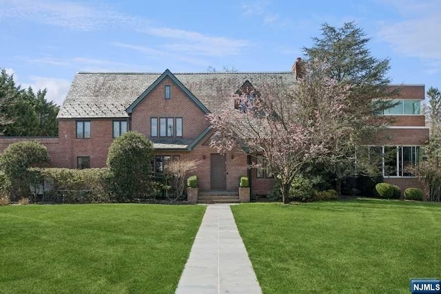 tudor-style house with a front lawn