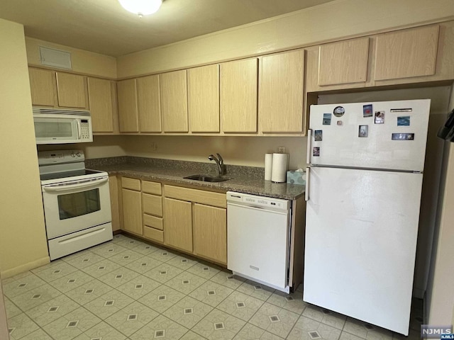 kitchen featuring light brown cabinetry, sink, and white appliances