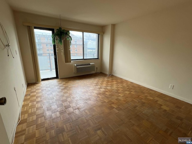 unfurnished room with parquet floors and a wall mounted air conditioner