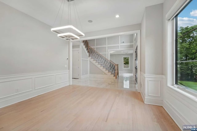 interior space with built in features, a wealth of natural light, and light hardwood / wood-style flooring