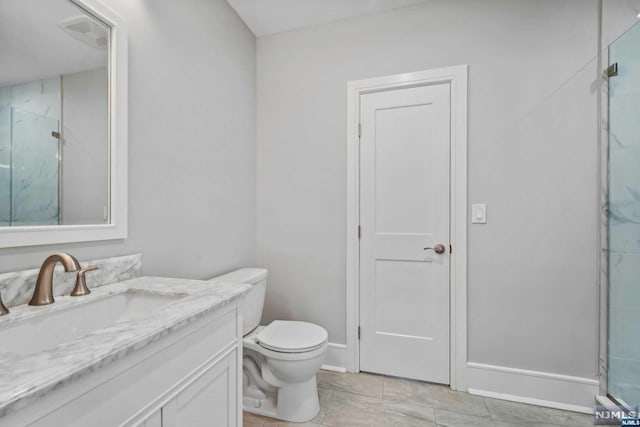 bathroom featuring tile patterned flooring, vanity, toilet, and walk in shower