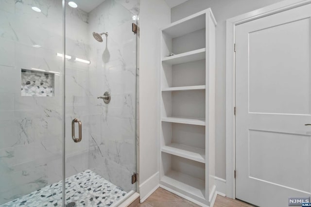 bathroom with built in shelves and an enclosed shower