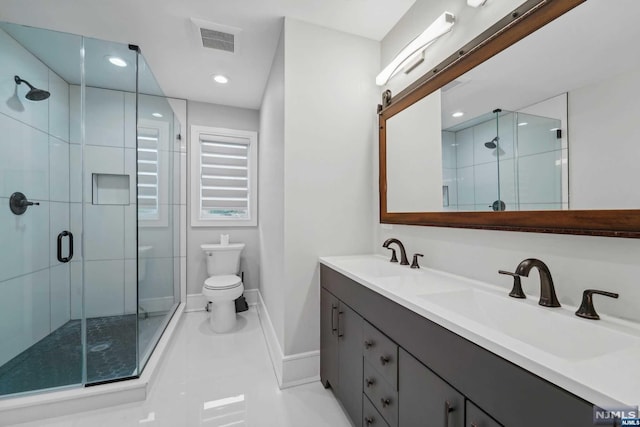 bathroom featuring tile patterned floors, vanity, a shower with shower door, and toilet