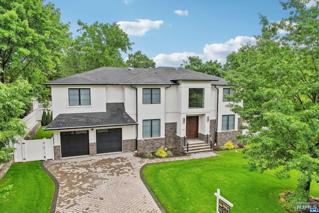 view of front of property featuring a garage and a front lawn