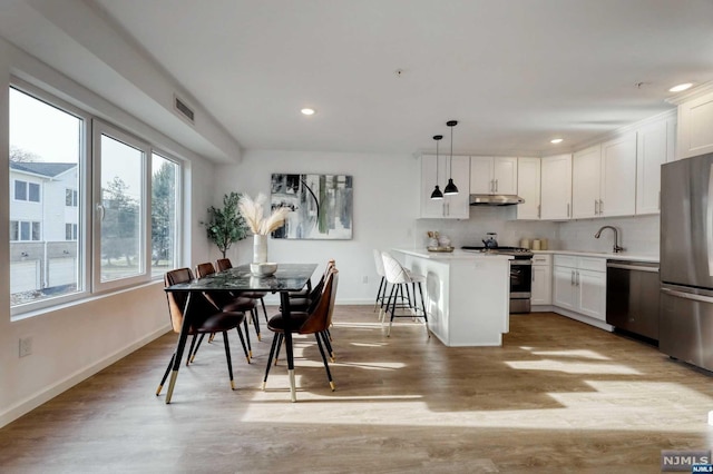 dining room with light wood-type flooring and sink