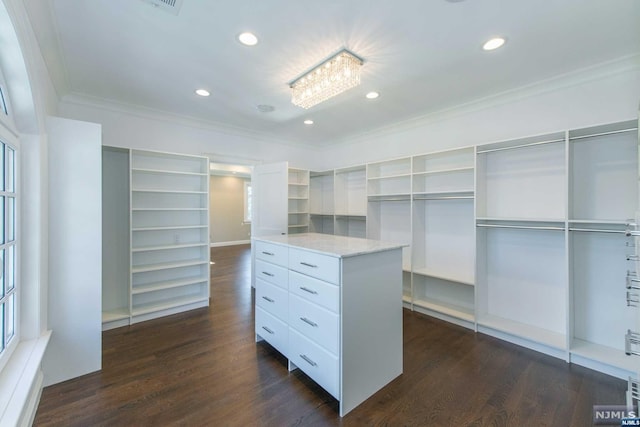 walk in closet featuring dark hardwood / wood-style flooring and a notable chandelier