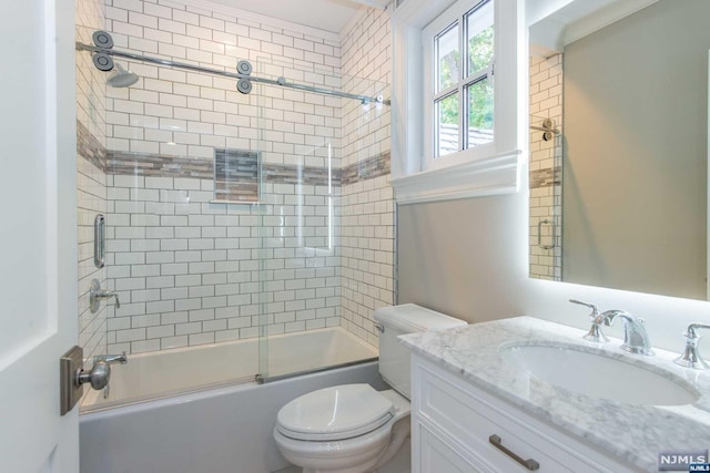 full bathroom featuring bath / shower combo with glass door, toilet, and vanity