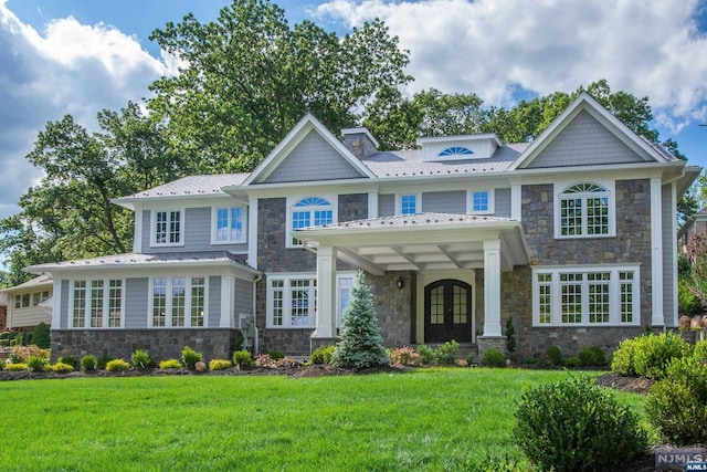 craftsman inspired home featuring a front lawn and french doors