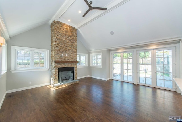 unfurnished living room with ceiling fan, vaulted ceiling with beams, a stone fireplace, french doors, and dark hardwood / wood-style flooring