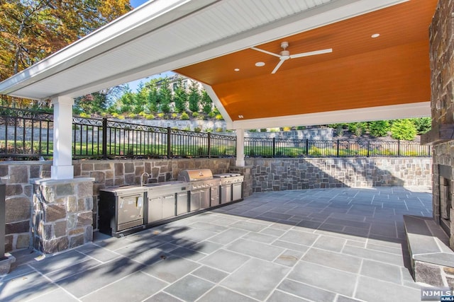 view of patio with ceiling fan, sink, an outdoor kitchen, and grilling area