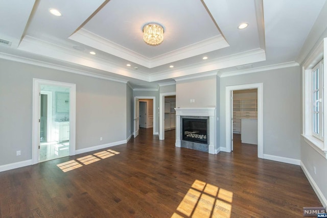 unfurnished living room with a tray ceiling, dark hardwood / wood-style flooring, and crown molding