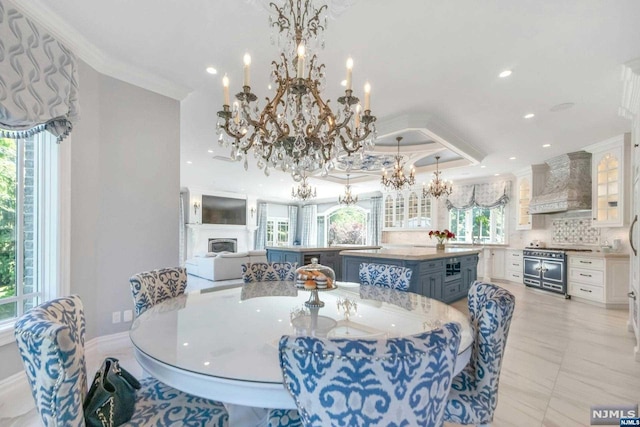 dining area featuring a wealth of natural light, ornamental molding, a raised ceiling, and a notable chandelier