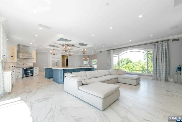 living room featuring sink, an inviting chandelier, and ornamental molding