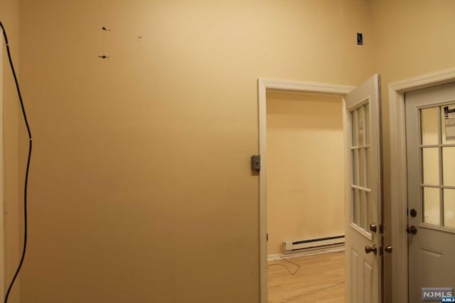 hallway with light hardwood / wood-style floors and a baseboard heating unit