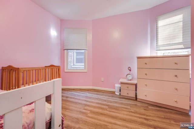 bedroom featuring multiple windows and light wood-type flooring