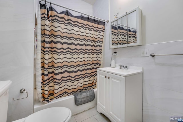 full bathroom featuring vanity, tile patterned floors, shower / bath combination with curtain, toilet, and tile walls