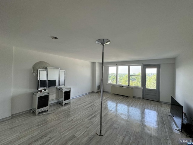 living room with radiator heating unit and light wood-type flooring