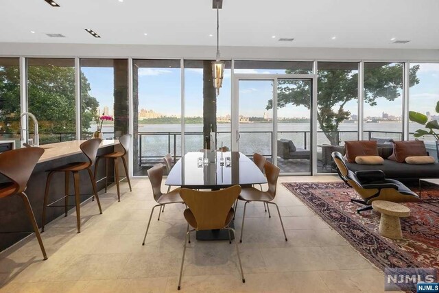 sunroom featuring a water view and a wealth of natural light