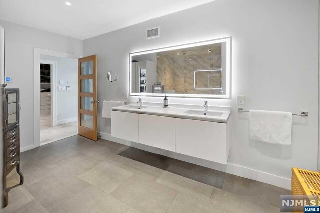 bathroom featuring tile patterned floors, vanity, and walk in shower