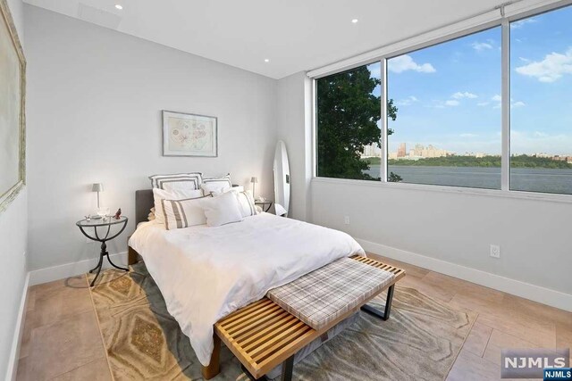 bedroom featuring a water view and light wood-type flooring