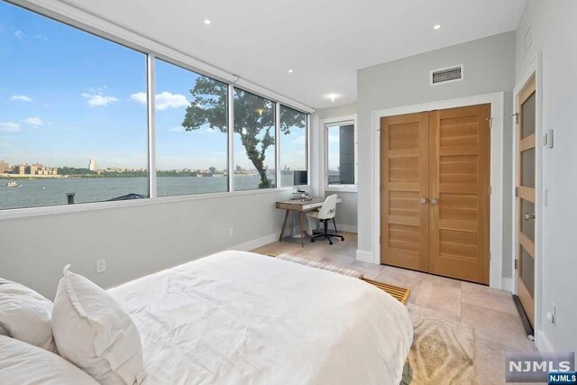 bedroom featuring a water view and a closet