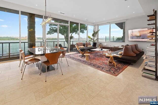 sunroom featuring a water view