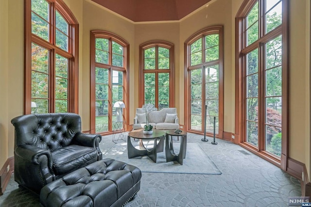 interior space with carpet, ornamental molding, and a towering ceiling