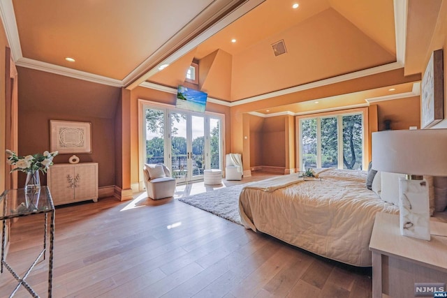 bedroom with wood-type flooring, ornamental molding, access to outside, and french doors