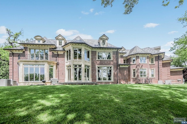 rear view of property featuring central AC, a yard, a balcony, and french doors