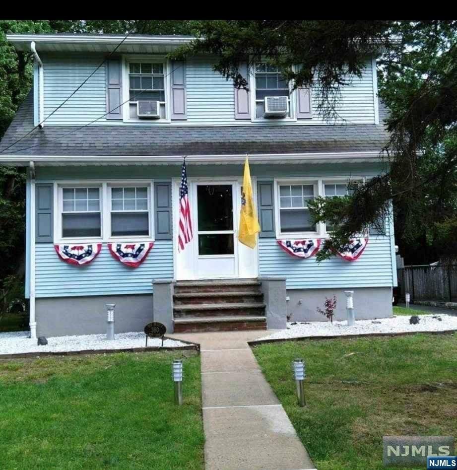 view of front property with cooling unit and a front yard