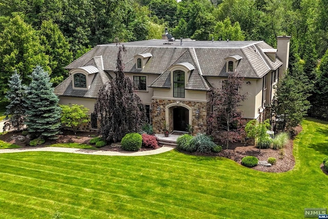 french country style house featuring a front yard