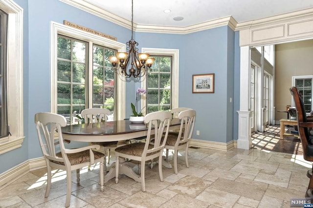 dining area with crown molding, a wealth of natural light, and an inviting chandelier