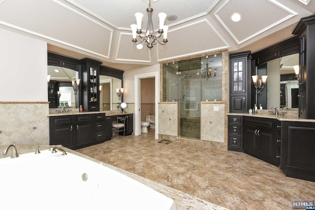 bathroom with vanity, tile walls, a bidet, and an inviting chandelier