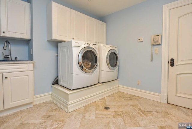 laundry room featuring cabinets, separate washer and dryer, and sink