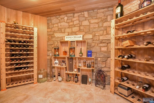 wine room featuring wood walls and wooden ceiling