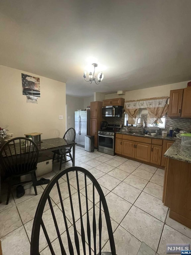 dining room with sink, light tile patterned floors, and a notable chandelier