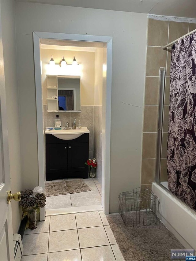 bathroom with tasteful backsplash, tile patterned flooring, vanity, and shower / tub combo