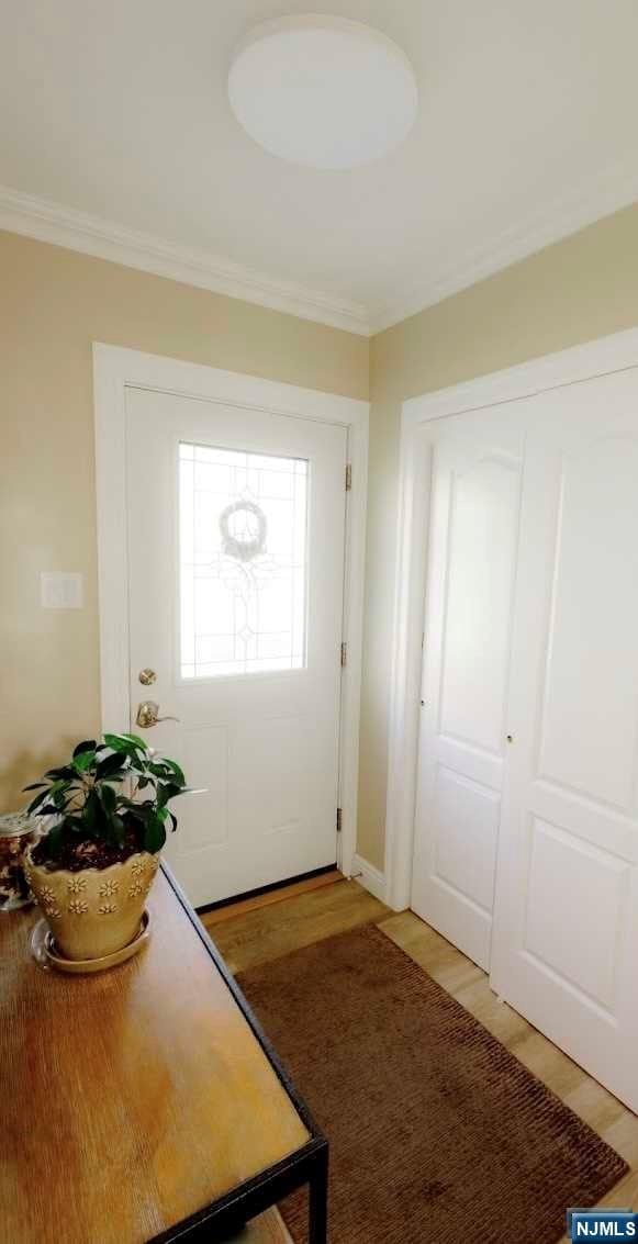 doorway featuring hardwood / wood-style floors and crown molding