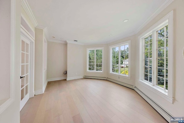 empty room with light hardwood / wood-style flooring, a baseboard heating unit, and crown molding