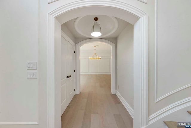 hall featuring a chandelier and light hardwood / wood-style flooring