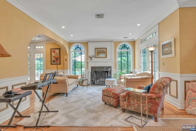 living room with crown molding and light wood-type flooring