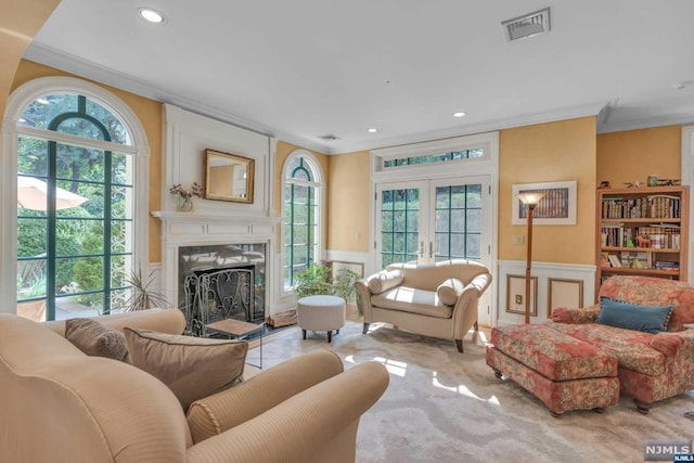 living room with a premium fireplace, french doors, and ornamental molding