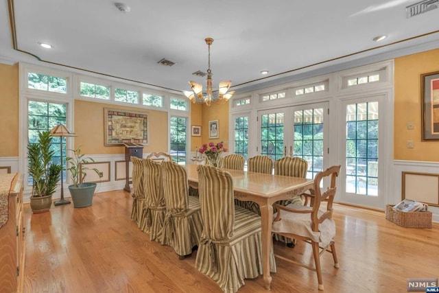 dining area with plenty of natural light, a chandelier, and light hardwood / wood-style flooring