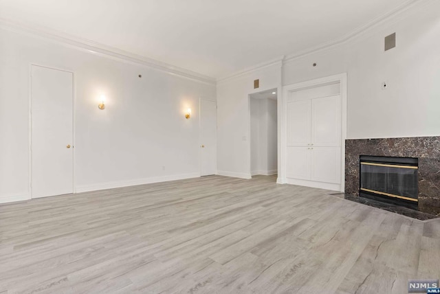 unfurnished living room with crown molding, light hardwood / wood-style flooring, and a high end fireplace