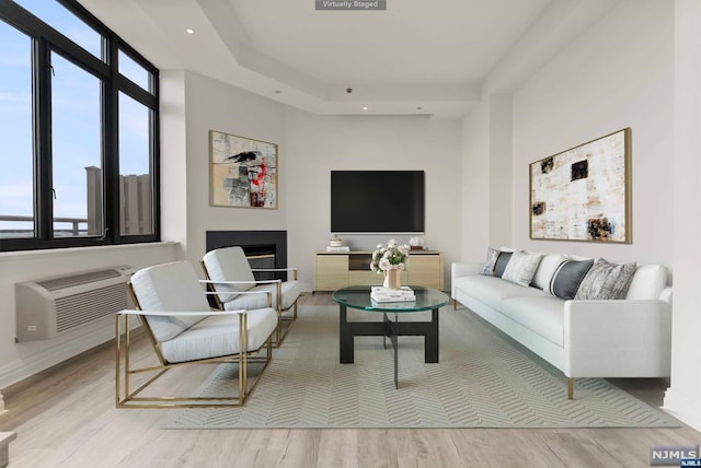 living room featuring an AC wall unit and light hardwood / wood-style flooring