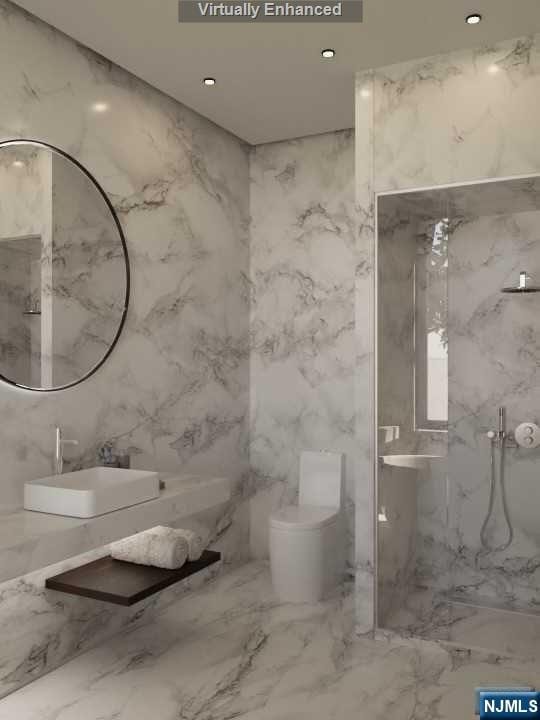 bathroom featuring a tile shower, toilet, tile walls, and sink