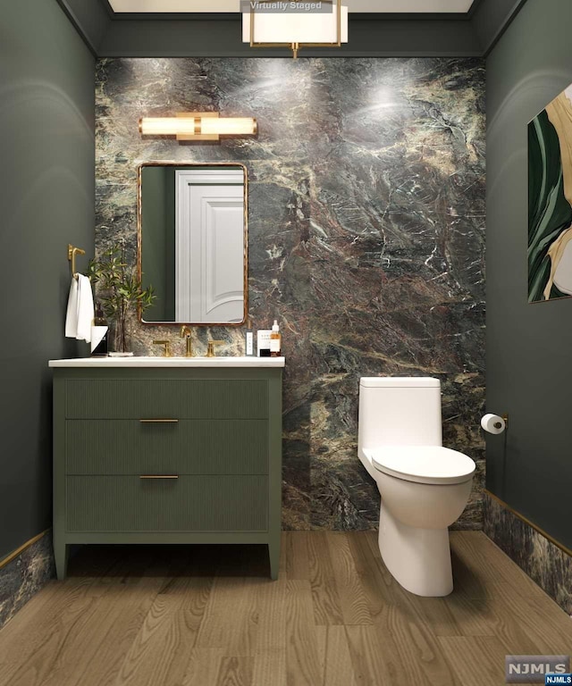 bathroom featuring vanity, wood-type flooring, and toilet